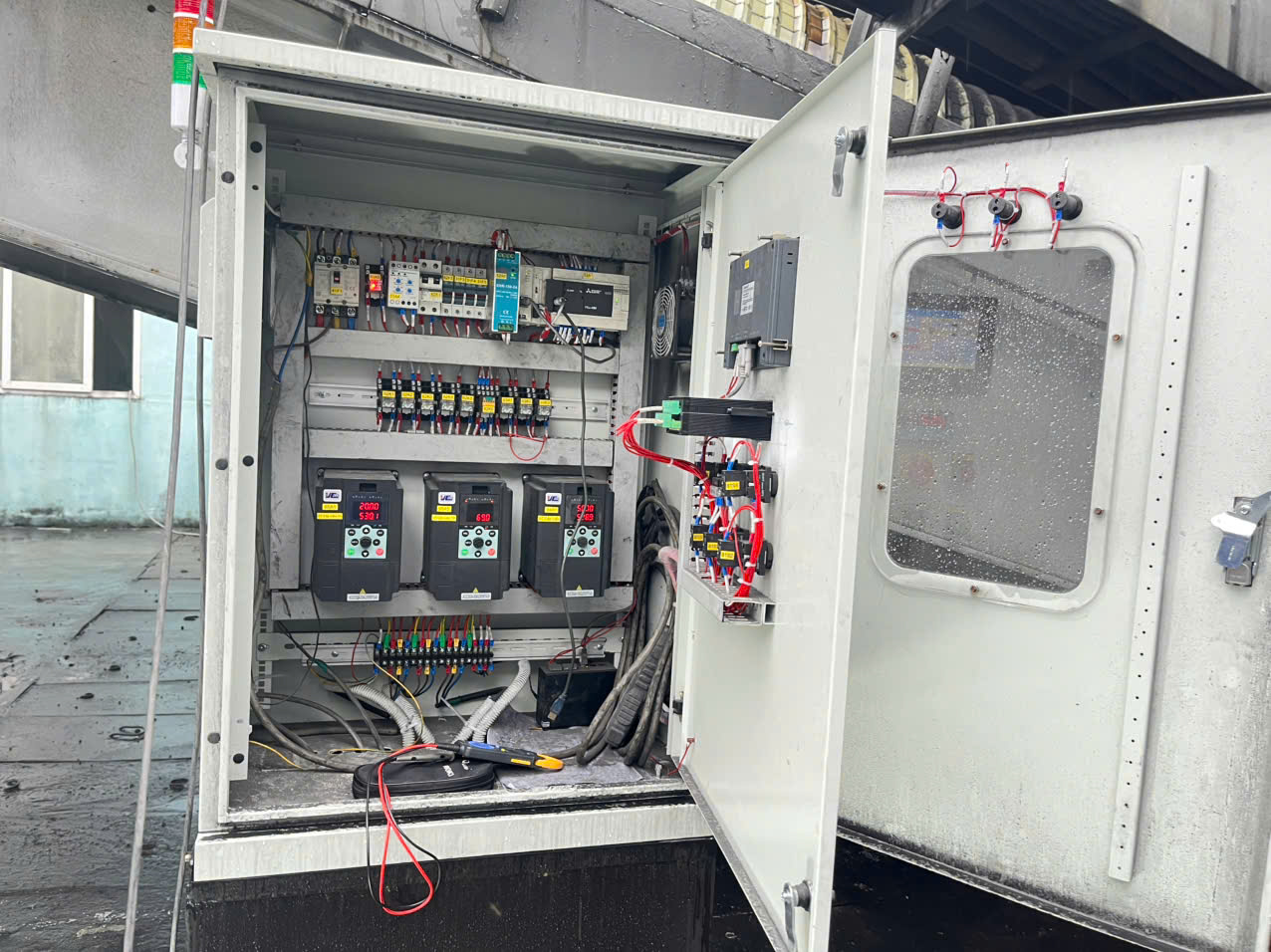 Tủ PLC và biến tần mở cửa, có đồng hồ đo và dụng cụ kiểm tra tại hiện trường