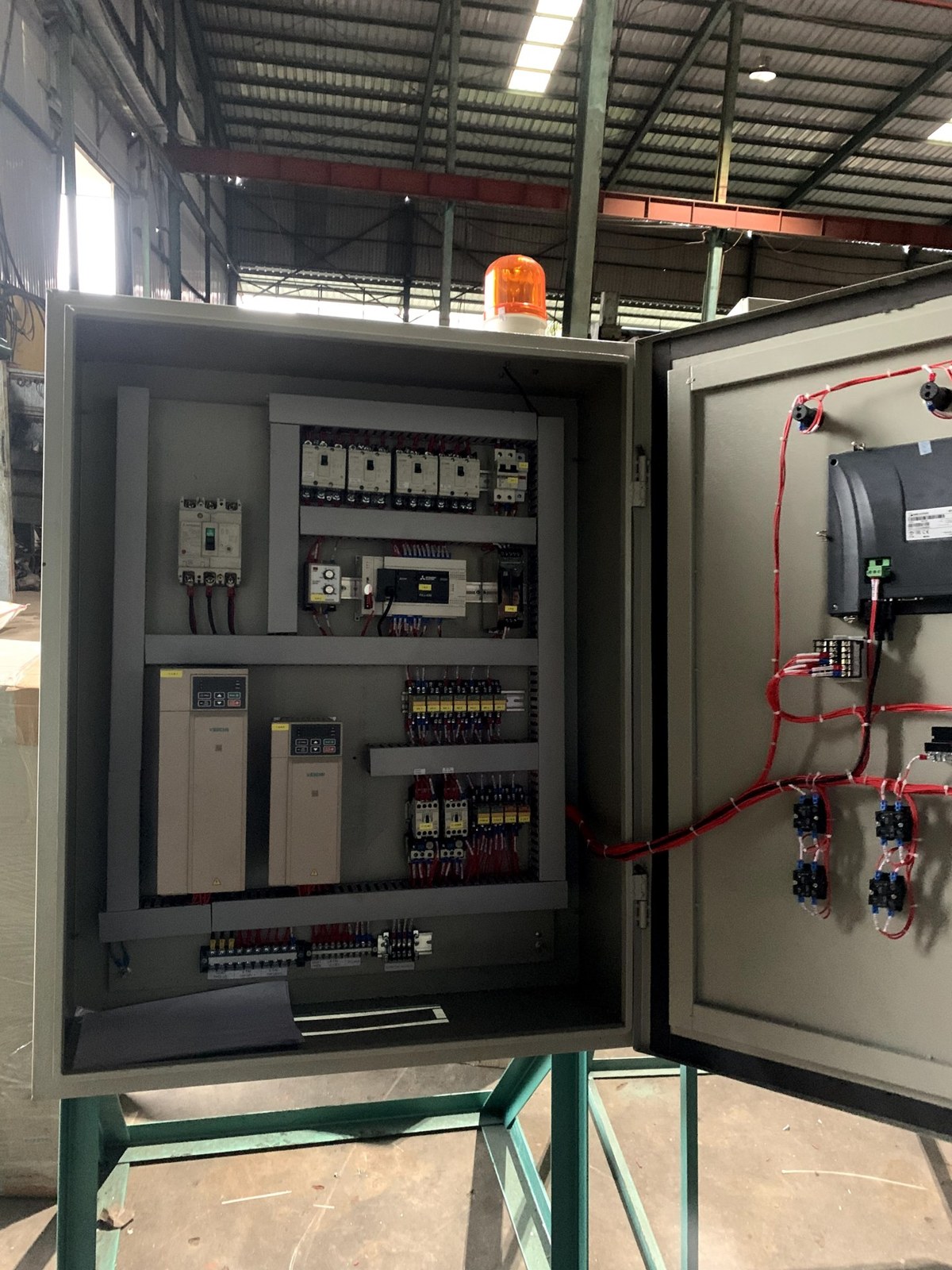 Tủ điều khiển có PLC, biến tần và HMI đặt cạnh máy